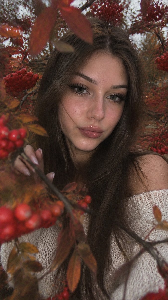 Нейросеть сделала осеннюю фотосессию у рябины: шатенка с длинными волосами держит ветку с ягодами