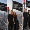ИИ-фото пары на вершине небоскрёба: три пары под чёрным флагом на шпиле Эмпайр-стейт-билдинг