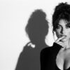 Фотосессия в стиле 90-х: чёрно-белый портрет со вспышкой и тенью на белой стене